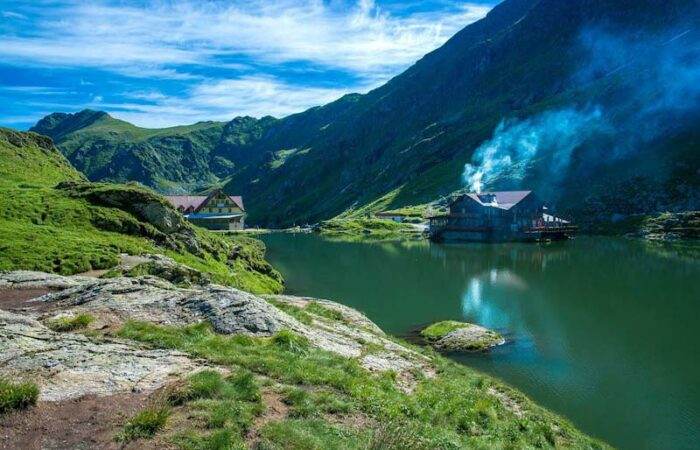 Aerial view of Romania’s Transfagarasan Highway snaking through the Carpathian Mountains surrounded by rugged cliffs.
