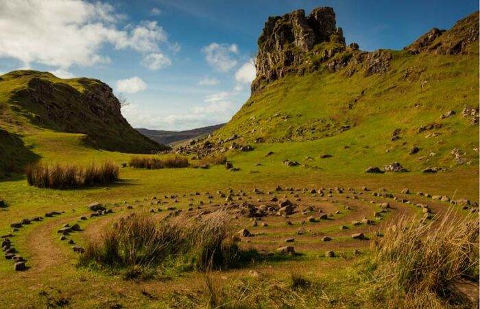 Breathtaking landscape of Isle of Skye in Scotland featuring rugged cliffs, rolling green hills, and dramatic skies